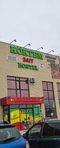 a store with a sign on the side of a building at Koktem hostel in Aktobe