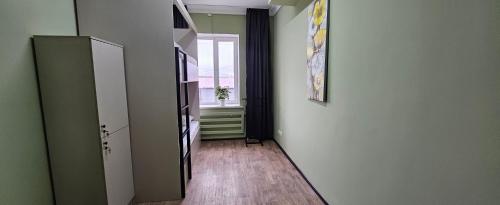 a hallway with a door to a room with a window at Koktem hostel in Aktobe