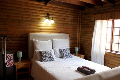 Un dormitorio con una cama en una cabaña de troncos en River Ridge Log Home - Inside Dinokeng Big 5, en Klipdrift