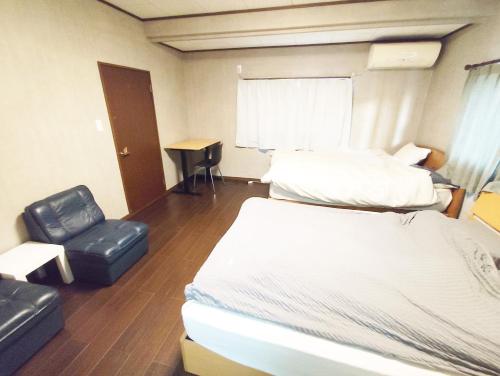 a hotel room with two beds and a chair at 12名迄OK 5LDK ビーチまで徒歩3分 BBQ完備 駐車場5台White sun villa in Shirako