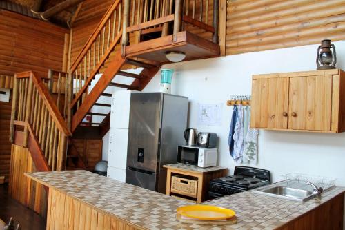 una cocina con refrigerador y encimera en River Ridge Log Home - Inside Dinokeng Big 5, en Klipdrift