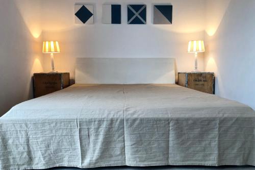 ein Schlafzimmer mit einem weißen Bett mit zwei Lampen in der Unterkunft NordseeResort Friesland NordseeResort Friesland 1 in Schillig