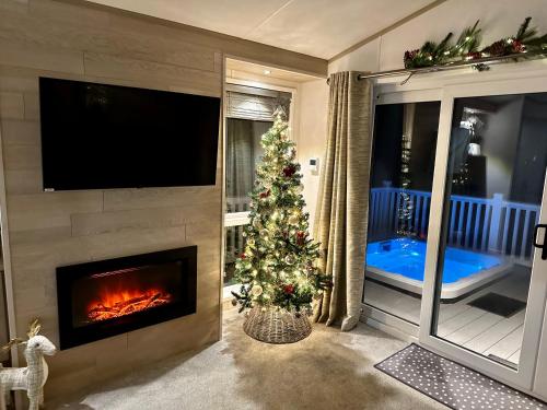 ein Wohnzimmer mit einem Weihnachtsbaum und einem Kamin in der Unterkunft Honey Bee Lodge With Hot Tub in York
