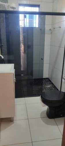 a bathroom with a black toilet and a shower at Casa Refúgio in Ibicoara