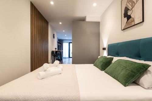 una camera da letto con un grande letto bianco con cuscini verdi di Cielo y Mar a Valencia