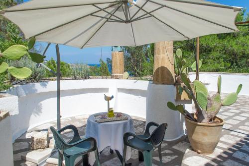 a table and chairs under an umbrella next to a pool at La Terrazza on Acquaviva in Marittima