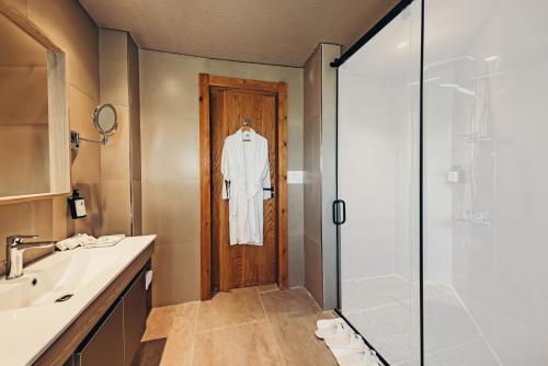 a bathroom with a robe hanging on a door at Azur White Resort Ras El Hekma in Zāwiyat al ‘Awwāmah