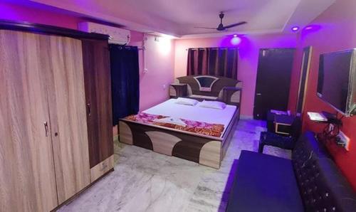 a bedroom with a bed with purple lights on it at FabHotel Rose in kolkata