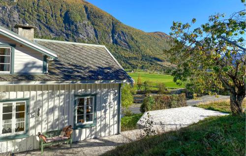 a white house with a bench next to a mountain at Beautiful Home In Vistdal With Wifi in Myklebostad