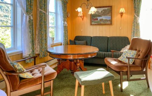 a living room with a table and chairs and a couch at Beautiful Home In Vistdal With Wifi in Myklebostad