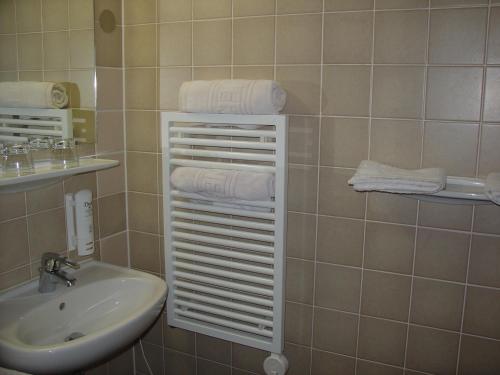 W łazience znajduje się umywalka i biały wieszak na ręczniki. w obiekcie Balneario Casa Pallotti w mieście Carranza