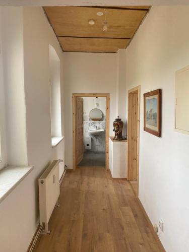 a hallway with white walls and a wooden ceiling at Gutshaus Kletzin mit Pool und Minigolf-Anlage in Siedenbrünzow