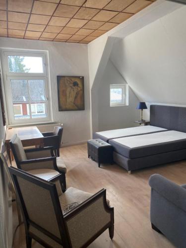 a bedroom with a bed and chairs in a room at Gutshaus Kletzin mit Pool und Minigolf-Anlage in Siedenbrünzow