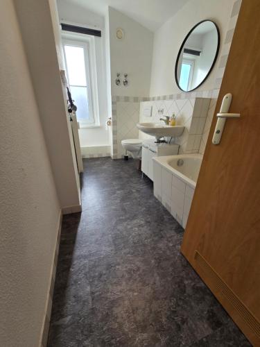 a bathroom with a sink and a tub and a mirror at FEWO "Anne" Großzügige Wohnung im Zentrum von Chemnitz in Chemnitz