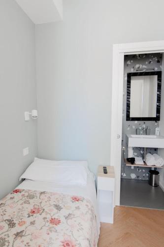 a white bedroom with a bed and a sink at A Casa Di Lu Na 3 in Bologna