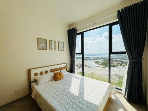une chambre avec un lit et une grande fenêtre dans l'établissement VINHOMES GRAND PARK QUẬN 9 Căn hộ LUXURY MASTERI CENTRE POINT, à Gò Công