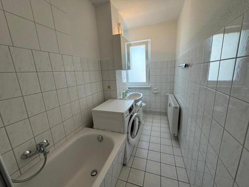 a bathroom with a tub and a washing machine at Schöne Gästewohnung zum Erholen in Bad Sülze