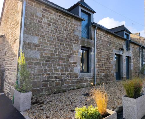 een bakstenen gebouw met twee potplanten ervoor bij Ker Loal 