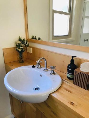 a bathroom with a white sink and a mirror at One Mile Bridge - Off Grid Stays in Mole Creek