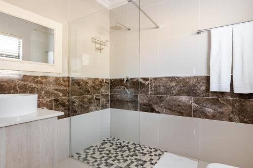 a bathroom with a shower with a glass door at Gosheni Villas in White River