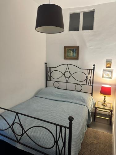 une chambre avec un lit recouvert d'une couette bleue et une lampe dans l'établissement Vieux Nice, à Nice