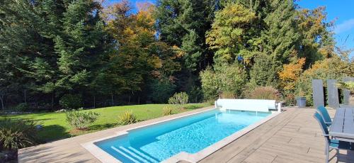 a swimming pool with a bench in a yard at Chez Jo in Le Valdahon