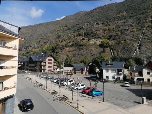 a street with cars parked in front of a mountain at Esterri Confort in Esterri d'Àneu