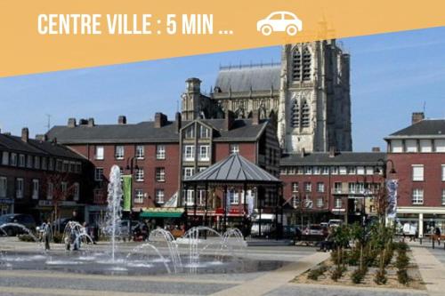a city with a fountain in front of a building at La Chaumière des 2 Cygnes-SPA- WIFI-Parking-Calme in Abbeville