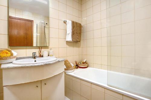 a bathroom with a sink and a bath tub at Casa Nóbrega in Caniço