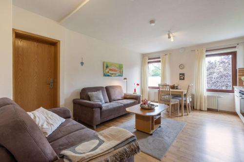 una sala de estar con un sofá y una mesa en Ferienwohnung 1, en Todendorf auf Fehmarn