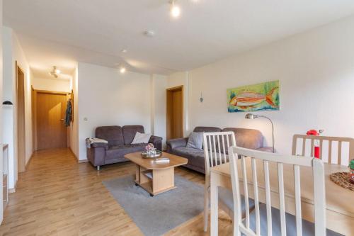 una sala de estar con un sofá y una mesa en Ferienwohnung 1, en Todendorf auf Fehmarn