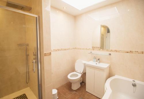 une salle de bain avec toilettes, lavabo et douche dans l'établissement Pebbles Beach House By Air Premier, à Seaford