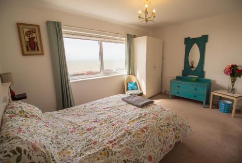 une chambre avec un lit, une commode et une fenêtre dans l'établissement Pebbles Beach House By Air Premier, à Seaford