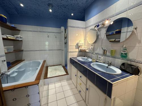 Un baño con dos lavabos y una bañera. en La masqueria, en Montgaillard