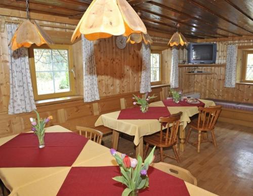 a dining room with tables and chairs and a tv at Hoamatlhütte in Schladming