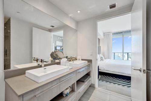 een badkamer met twee wastafels en een grote spiegel bij Amazing Apartments At H Beach House in Hollywood