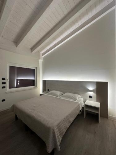 a white bedroom with a bed and a tv at Confidence Hotel Viadana in Viadana
