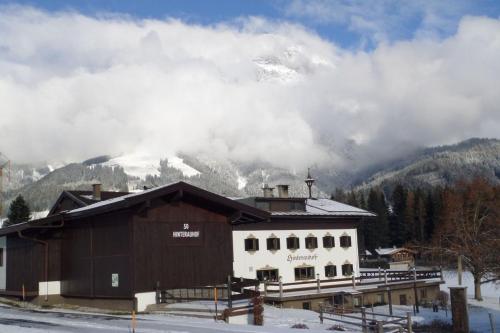 a building with a snow covered mountain in the background at Hinterauhof in Rain