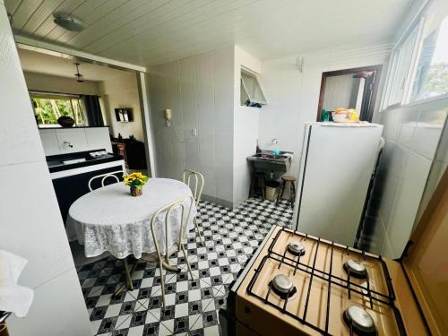 a small kitchen with a table and a refrigerator at COP 30, Mosqueiro - Apto pé na areia in Belém