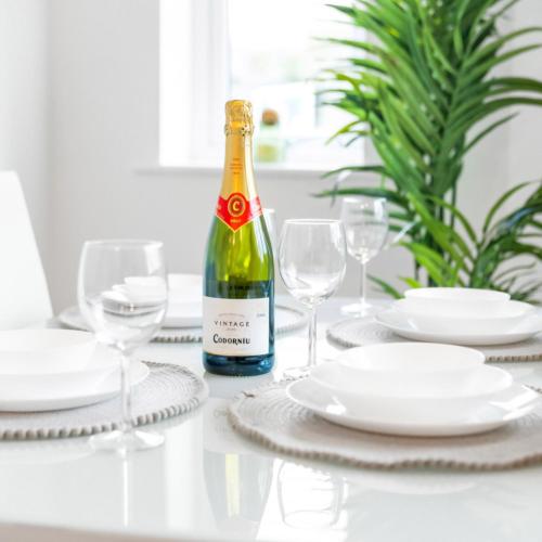 a bottle of wine sitting on a table with glasses at Two Bedrooms Apartment - Parking - Cradley Heath 51C in Netherton