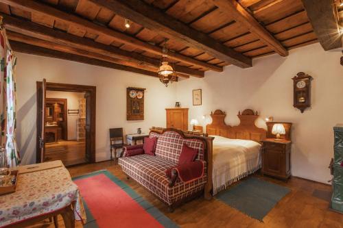 a bedroom with a bed and a couch and a table at Count Kálnoky's Transylvanian Guesthouses in Micloşoara
