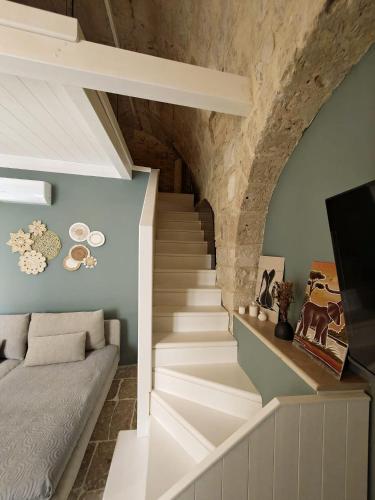 a staircase in a house with a stone wall at Domus Gabriel - Palazzo Paglia in Giovinazzo
