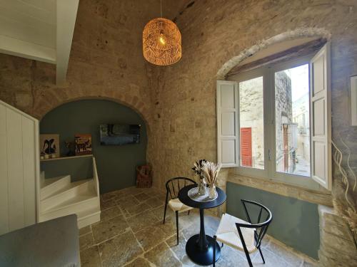 ein Esszimmer mit einem Tisch und einem Fenster in der Unterkunft Domus Gabriel - Palazzo Paglia in Giovinazzo