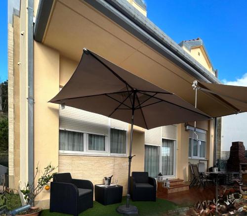 ein großer Regenschirm vor einem Haus in der Unterkunft Villa Laura in Boó de Piélagos