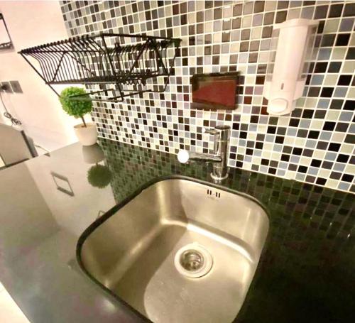 a sink in a bathroom with black and white tiles at Apartment Serenity Wongamat in Pattaya North