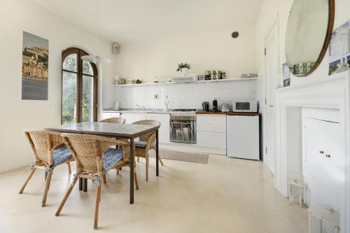 a dining room with a table and chairs and a kitchen at Villa Paolo Lemon Tree in Portovenere