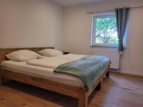 a bedroom with a wooden bed with a window at Reload Apartments - FeWo3 im Remmeker Feld in Bad Arolsen