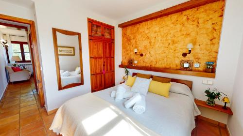 a bedroom with a bed with yellow and white pillows at Casa Las Tinajas in Alcalá de la Selva