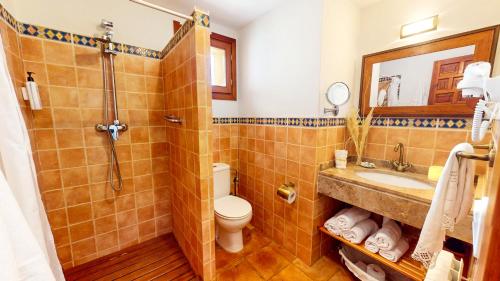 a bathroom with a toilet and a sink at Casa Las Tinajas in Alcalá de la Selva