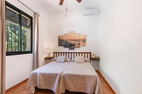 a bedroom with a bed in a white room at Villa Durán in Cantillana